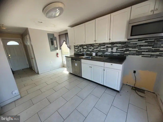 a kitchen with stainless steel appliances a sink a stove a microwave and cabinets