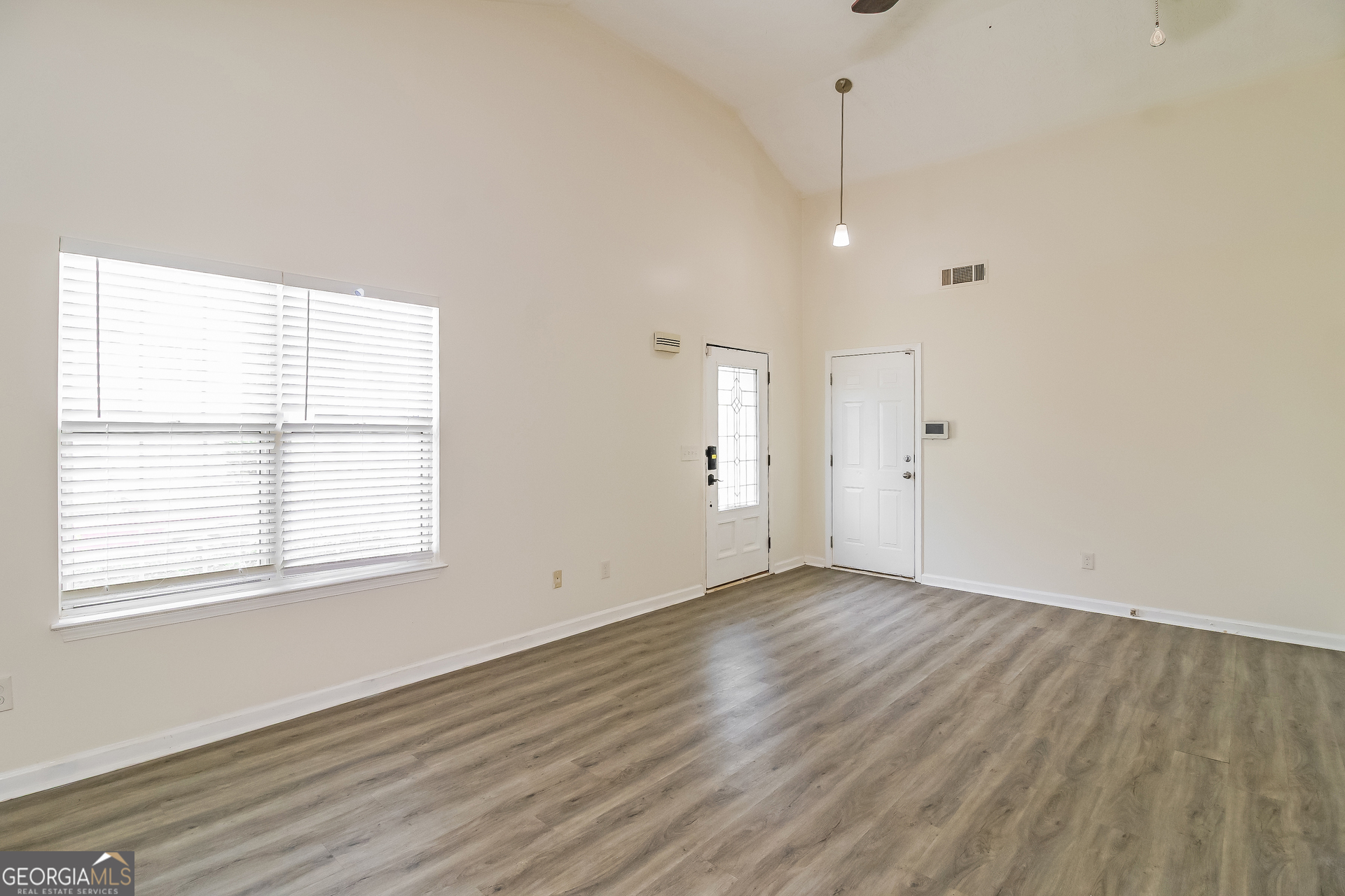 7023 Setters Way Lithonia, GA 30038 - Photo 5 of 21 a view of an empty room with wooden floor and a window
