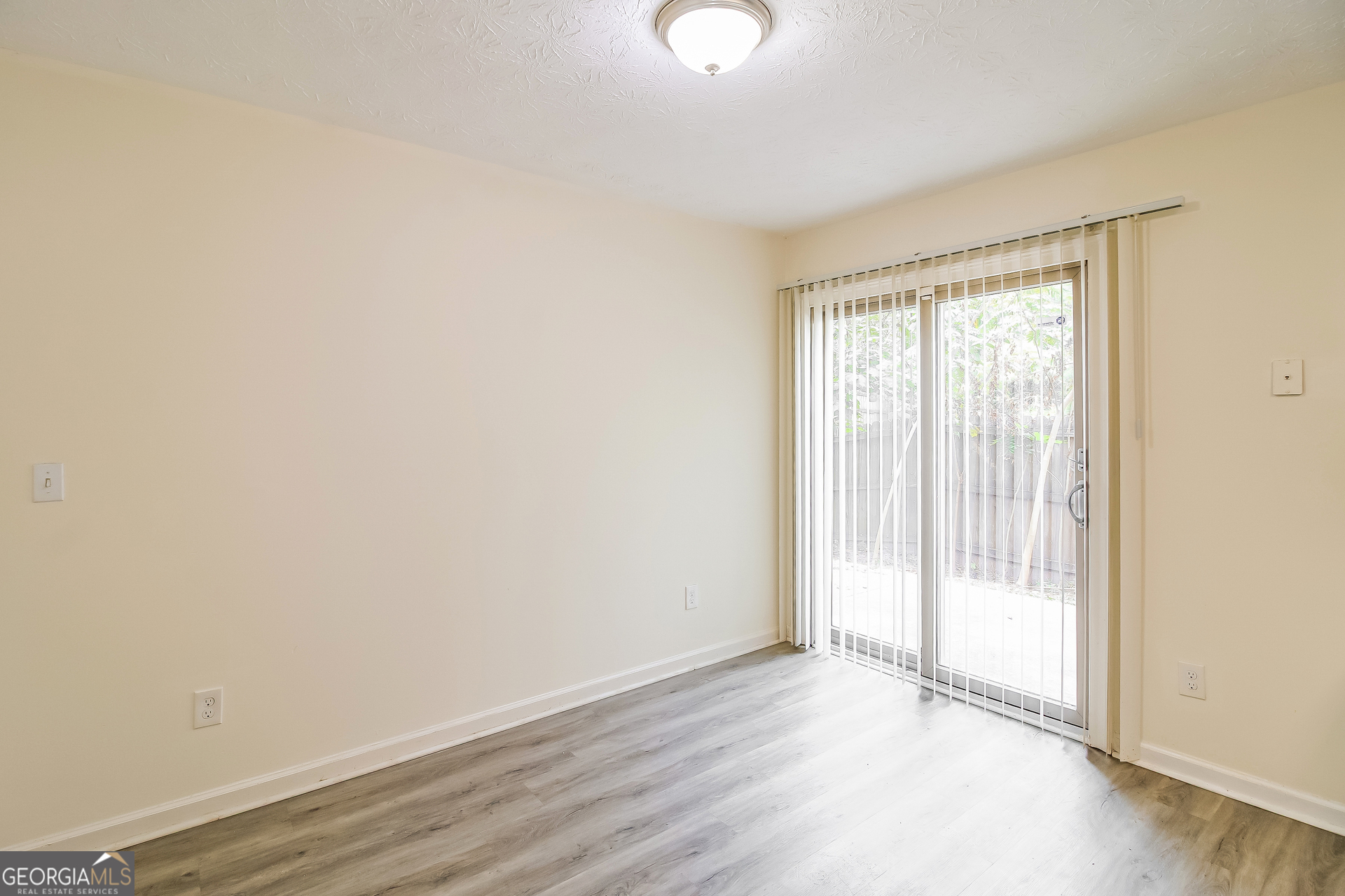 7023 Setters Way Lithonia, GA 30038 - Photo 6 of 21 an empty room with wooden floor and windows