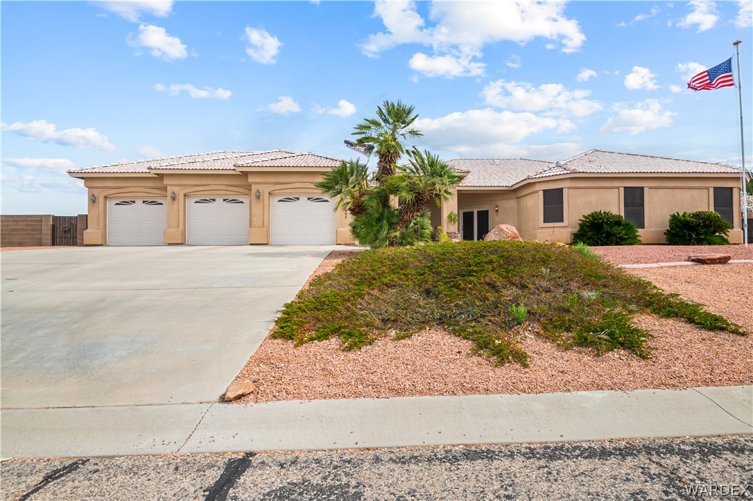 2898 Mountain Trail Road Kingman, AZ 86401 - Photo 34 of 75 a front view of a house with a yard and garage