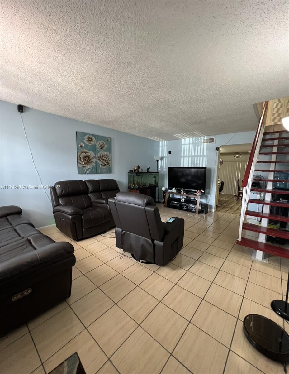 5866 West 18th Avenue, Unit 3023 Hialeah, FL 33012 - Photo 2 of 10 a living room with furniture and a lamp