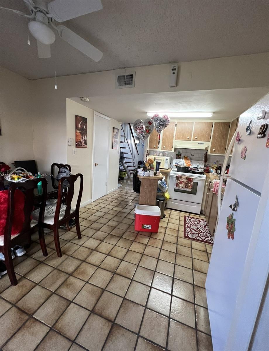 5866 West 18th Avenue, Unit 3023 Hialeah, FL 33012 - Photo 4 of 10 a living room with furniture and a chandelier