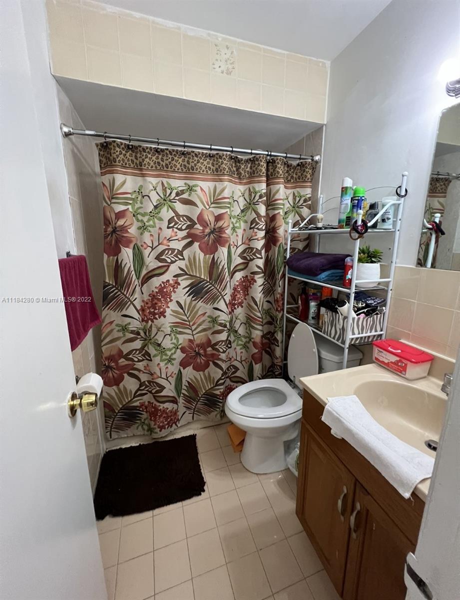 5866 West 18th Avenue, Unit 3023 Hialeah, FL 33012 - Photo 9 of 10 a bathroom with a toilet and a shower curtain