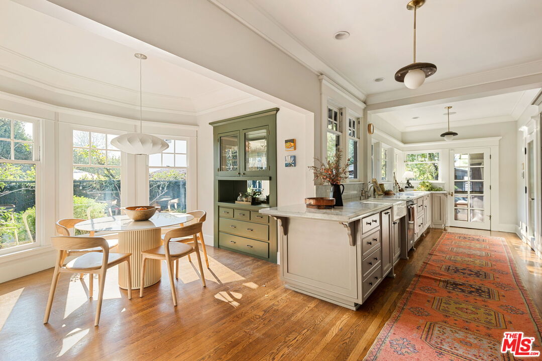 375 North Ridgewood Place Los Angeles, CA 90004 - Photo 16 of 56 a large white kitchen with living room and wooden floors