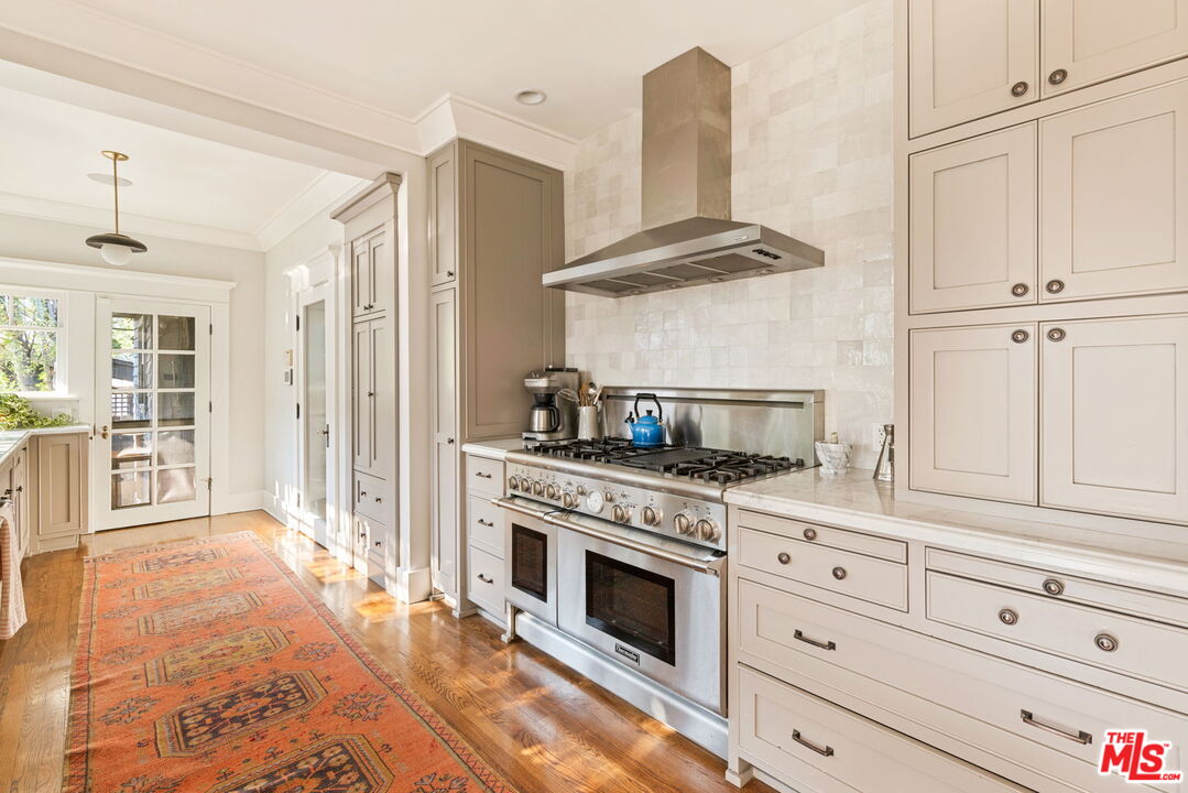 375 North Ridgewood Place Los Angeles, CA 90004 - Photo 20 of 56 a kitchen with stainless steel appliances granite countertop a stove and a sink
