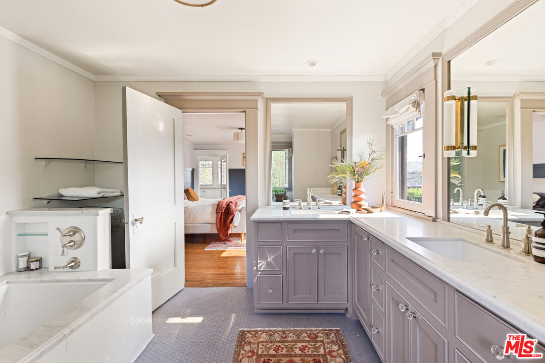 375 North Ridgewood Place Los Angeles, CA 90004 - Photo 32 of 56 a large bathroom with a double vanity sink a mirror and a bathtub