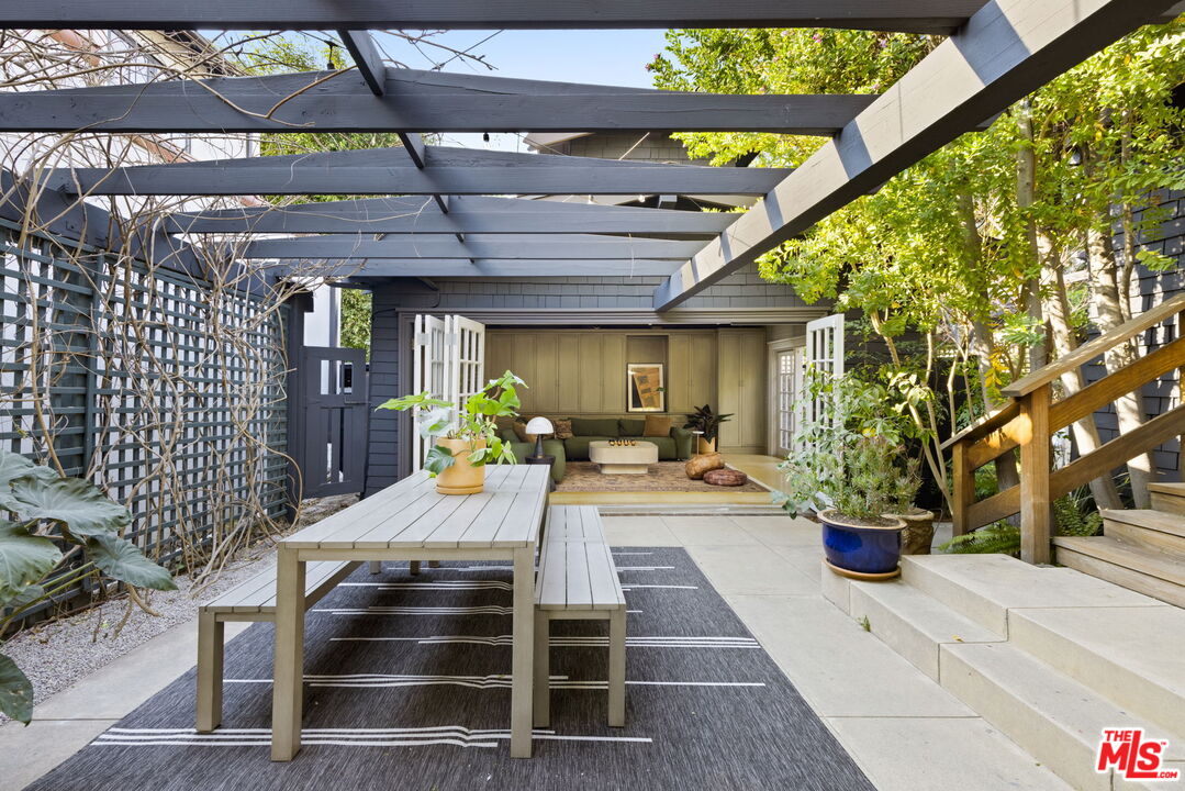 375 North Ridgewood Place Los Angeles, CA 90004 - Photo 44 of 56 a view of a patio with table and chairs potted plants and large tree