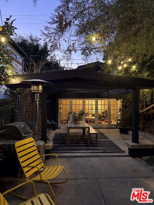 375 North Ridgewood Place Los Angeles, CA 90004 - Photo 53 of 56 a view of a patio with table and chairs potted plants with wooden floor and fence