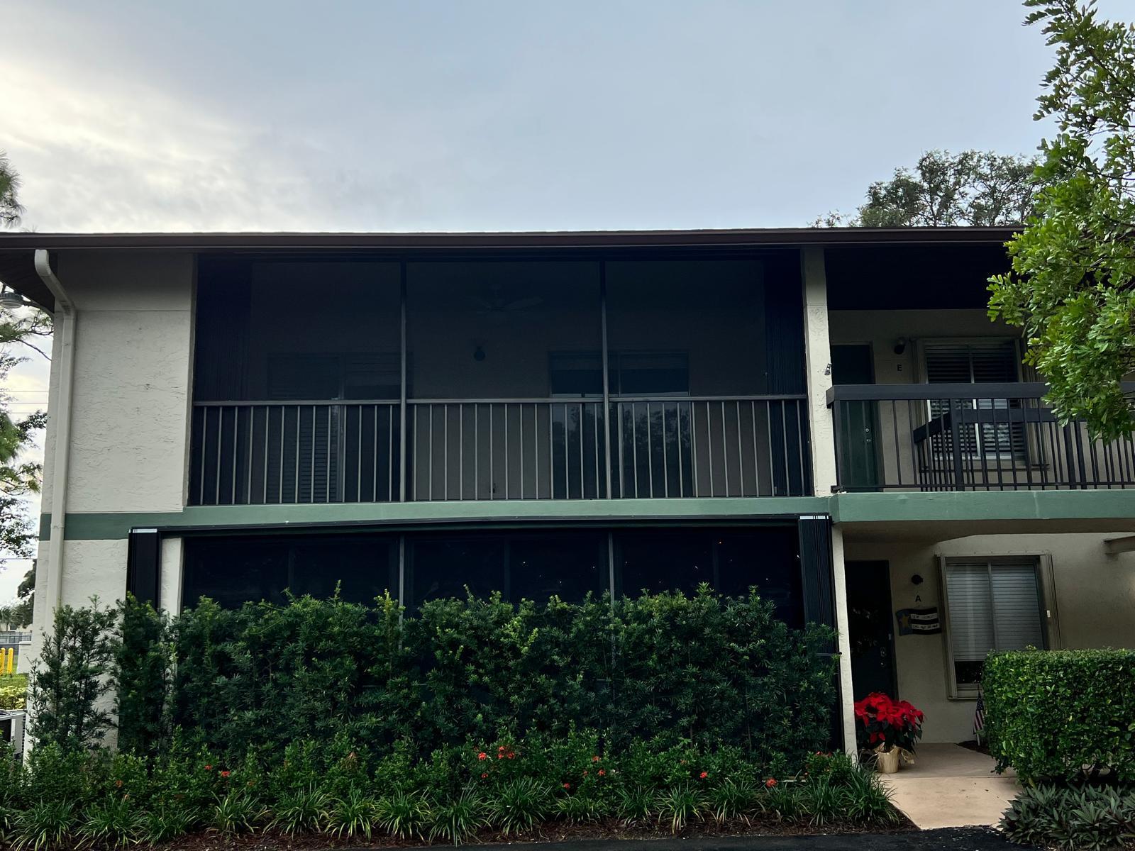 6342 Chasewood Drive, Unit E Jupiter, FL 33458 - Photo 1 of 7 a wooden fence with some plants in the background