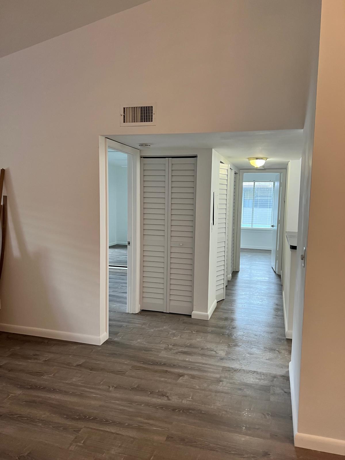 6342 Chasewood Drive, Unit E Jupiter, FL 33458 - Photo 5 of 7 a view of a hallway with wooden floor and closet