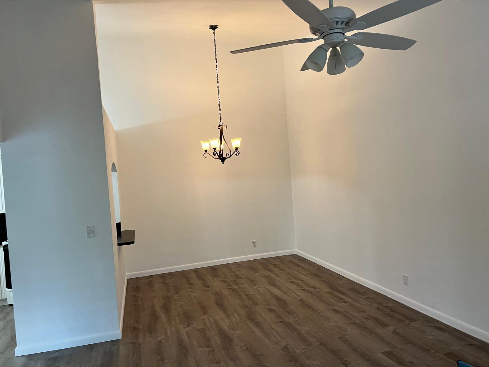 6342 Chasewood Drive, Unit E Jupiter, FL 33458 - Photo 6 of 7 a view of a room with a hanging light and wood floor