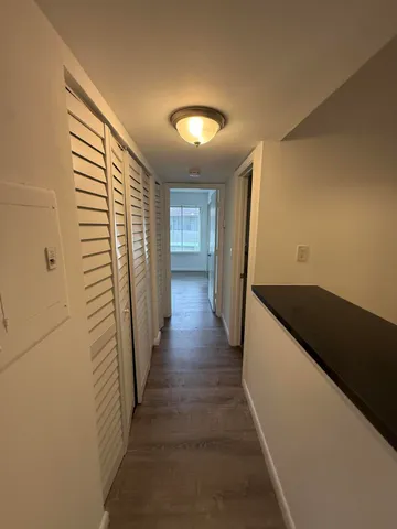 a view of a hallway with wooden floor and staircase