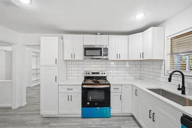 a kitchen with cabinets and appliances