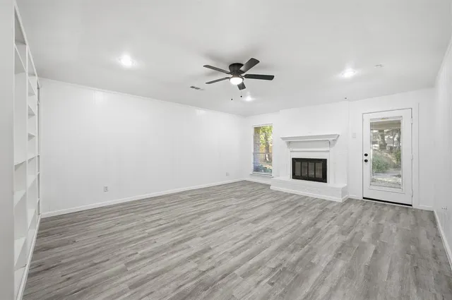 a view of empty room with wooden floor and fireplace