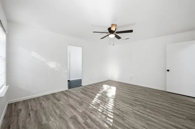 a view of a big room with wooden floor closet and windows