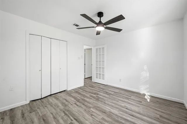 a view of empty room with wooden floor