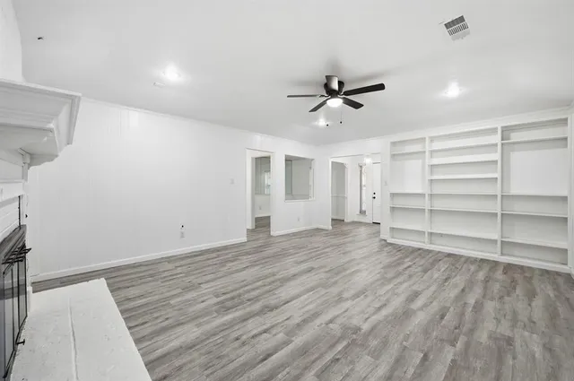 a view of a room with wooden floor and ceiling fan