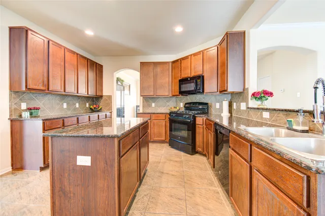 a kitchen with stainless steel appliances granite countertop wooden cabinets a sink and dishwasher