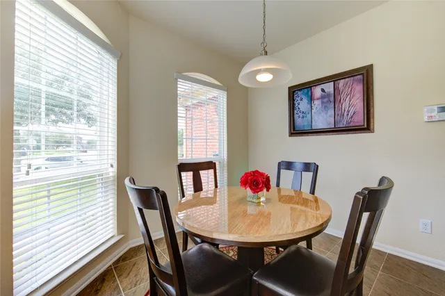 a dining room with furniture a chandelier and window