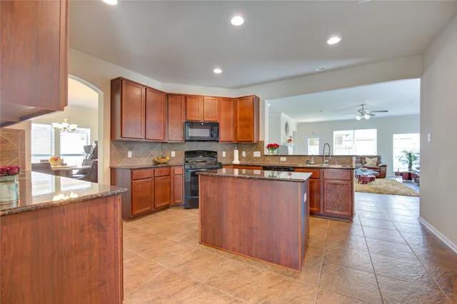 a kitchen with stainless steel appliances granite countertop a stove sink and cabinets