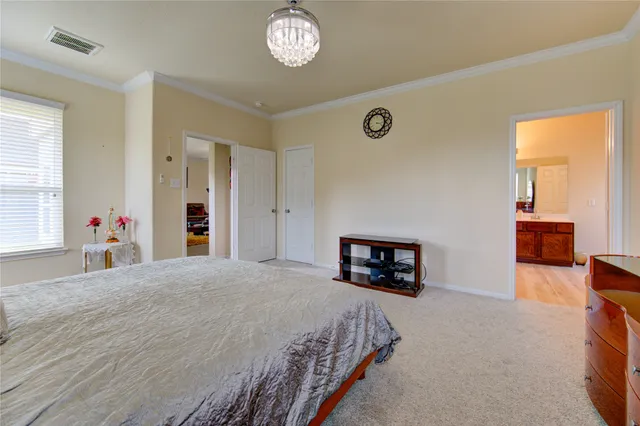 a spacious bedroom with a bed and wooden floor
