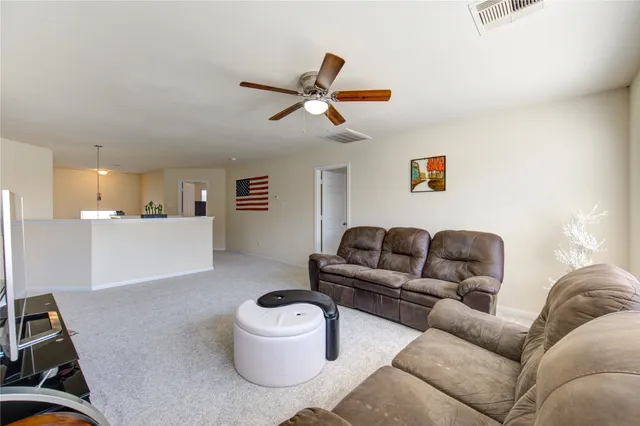 a living room with furniture and a view of kitchen