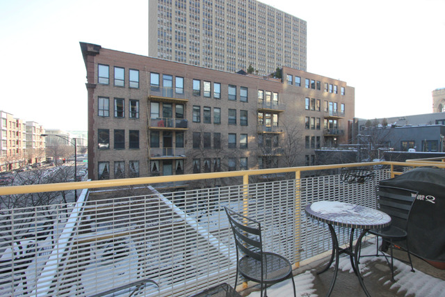 1910 South Indiana Avenue, Unit 321 Chicago, IL 60616 - Photo 20 of 25 a view of a roof deck with table and chairs and wooden floor