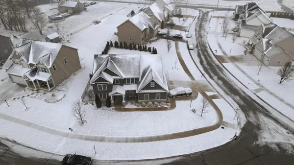 a kitchen with stainless steel appliances kitchen island granite countertop a refrigerator a sink dishwasher a stove top oven a dining table and chairs with wooden floor