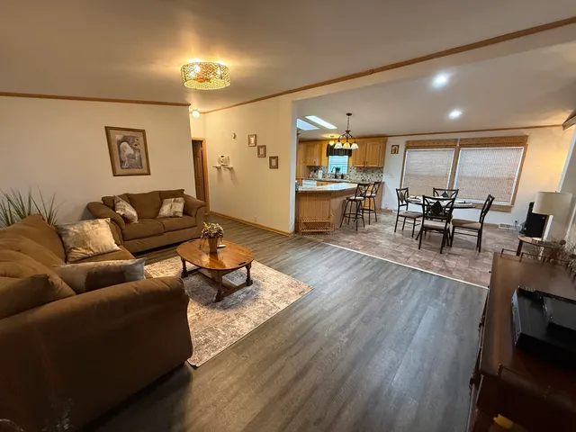 a living room with furniture and view of kitchen