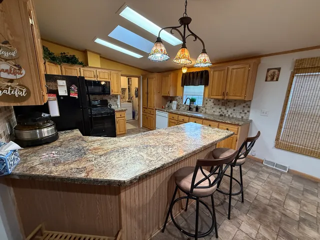 a room with stainless steel appliances kitchen island granite countertop furniture and a kitchen view
