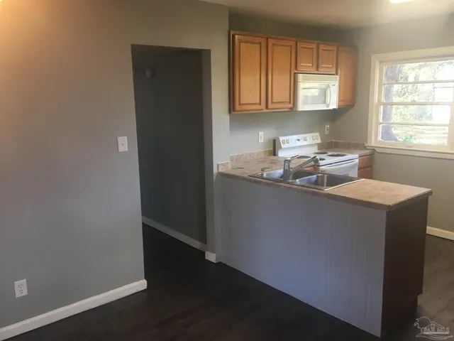 a kitchen with granite countertop cabinets and window