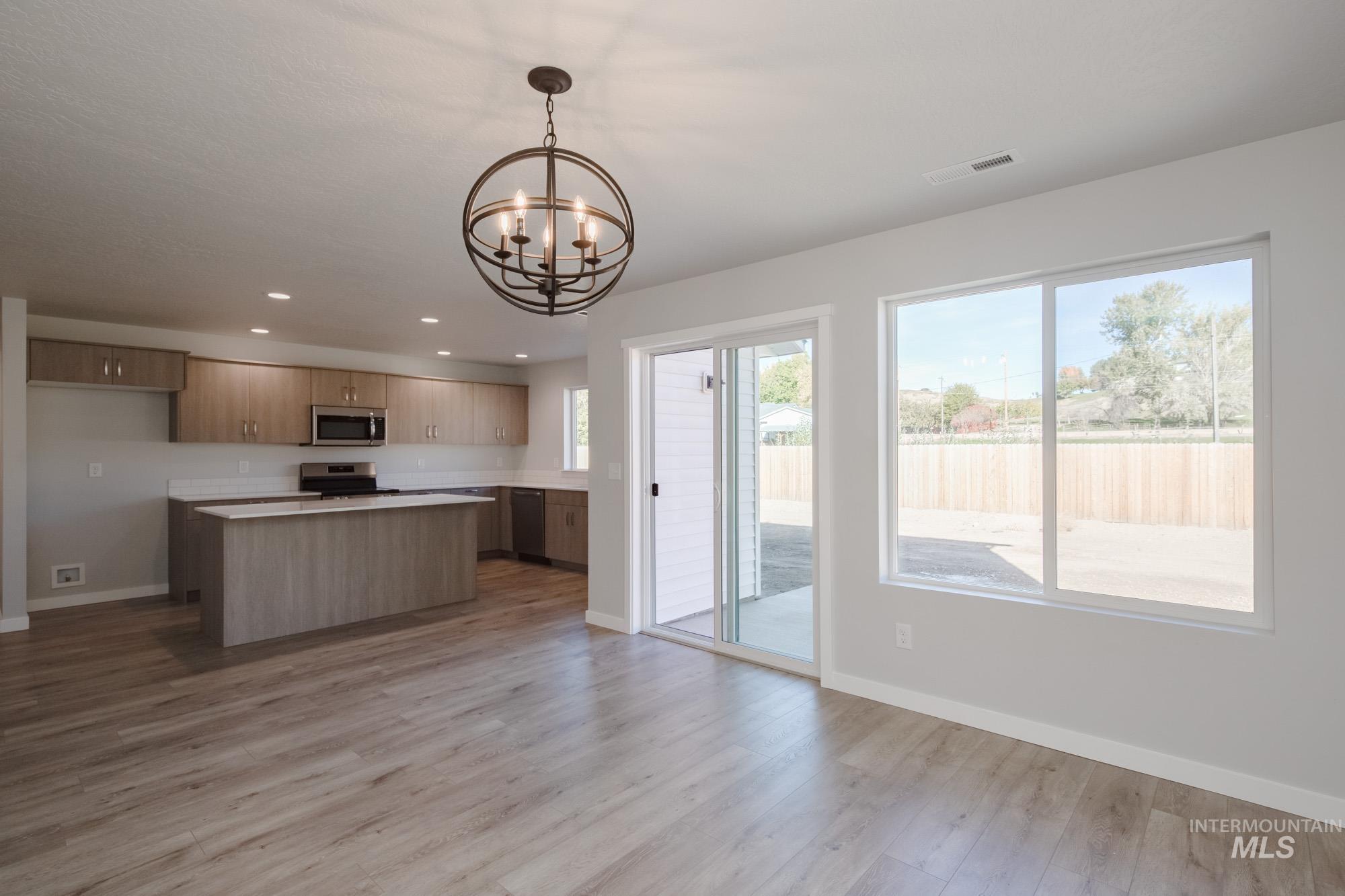 1732 Webb Brk Street Middleton, ID 83644 - Photo 29 of 29 Kitchen featuring a kitchen island, hanging light fixtures, recessed lighting, light countertops, and open floor plan