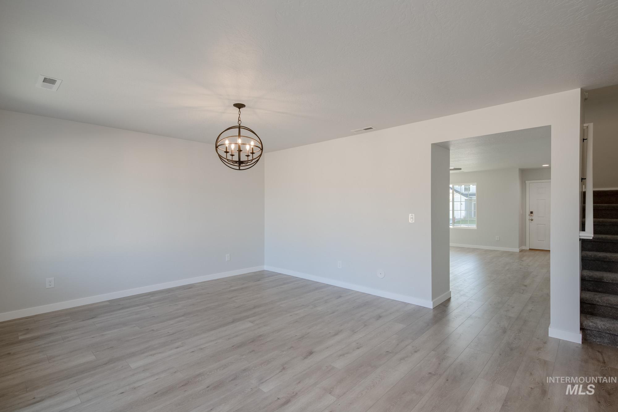 1732 Webb Brk Street Middleton, ID 83644 - Photo 18 of 29 Spare room with light wood-style floors, stairs, and a chandelier