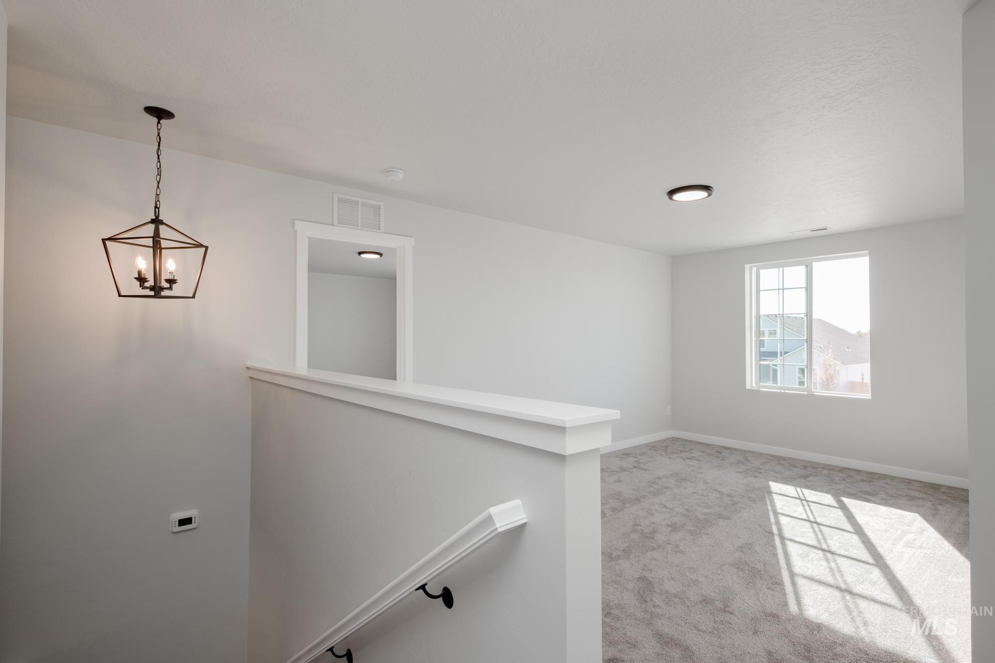 1732 Webb Brk Street Middleton, ID 83644 - Photo 22 of 29 Unfurnished room with light colored carpet and a chandelier