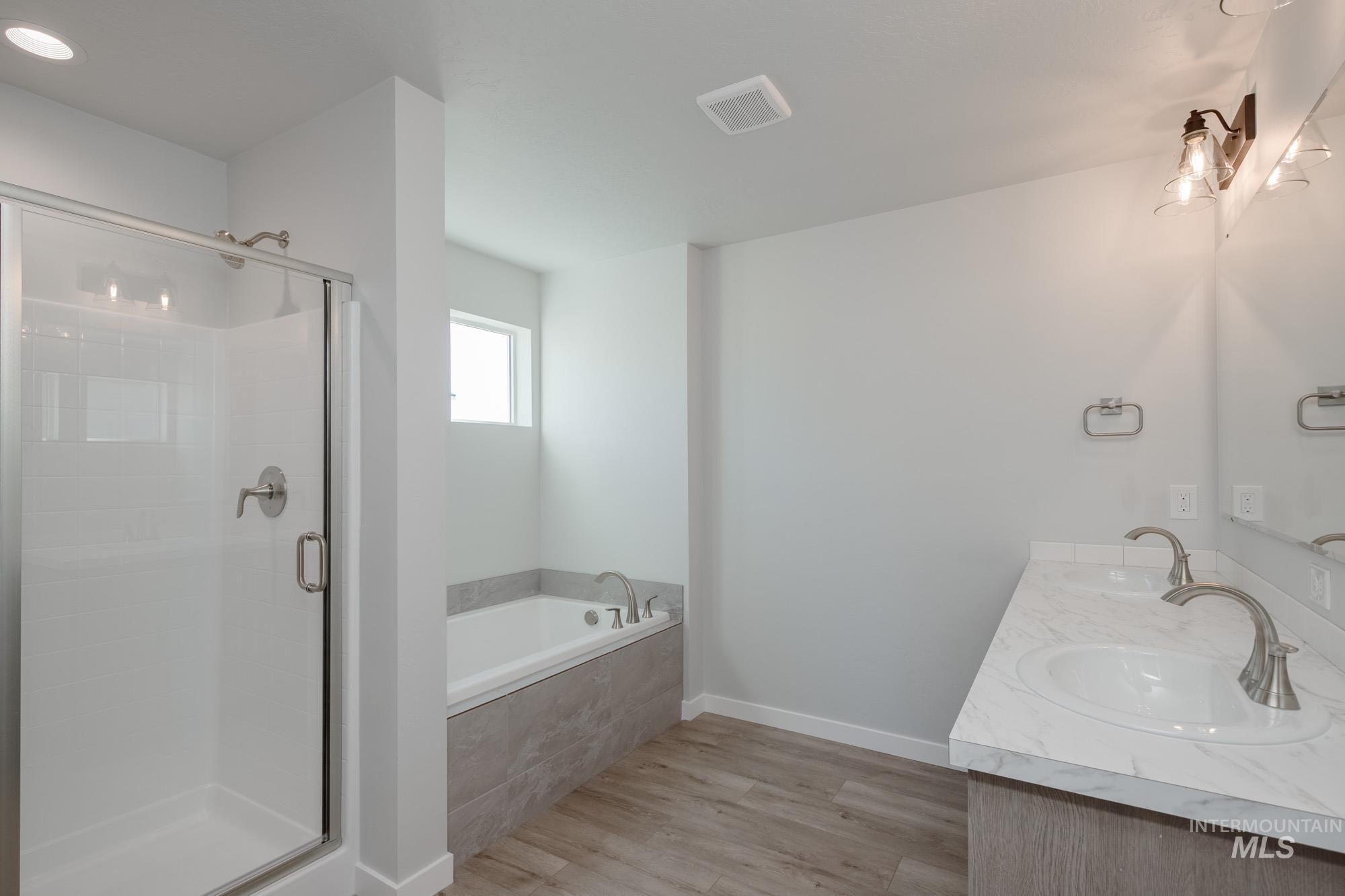 1732 Webb Brk Street Middleton, ID 83644 - Photo 26 of 29 Full bath featuring light wood-style flooring, double vanity, a shower stall, and a garden tub