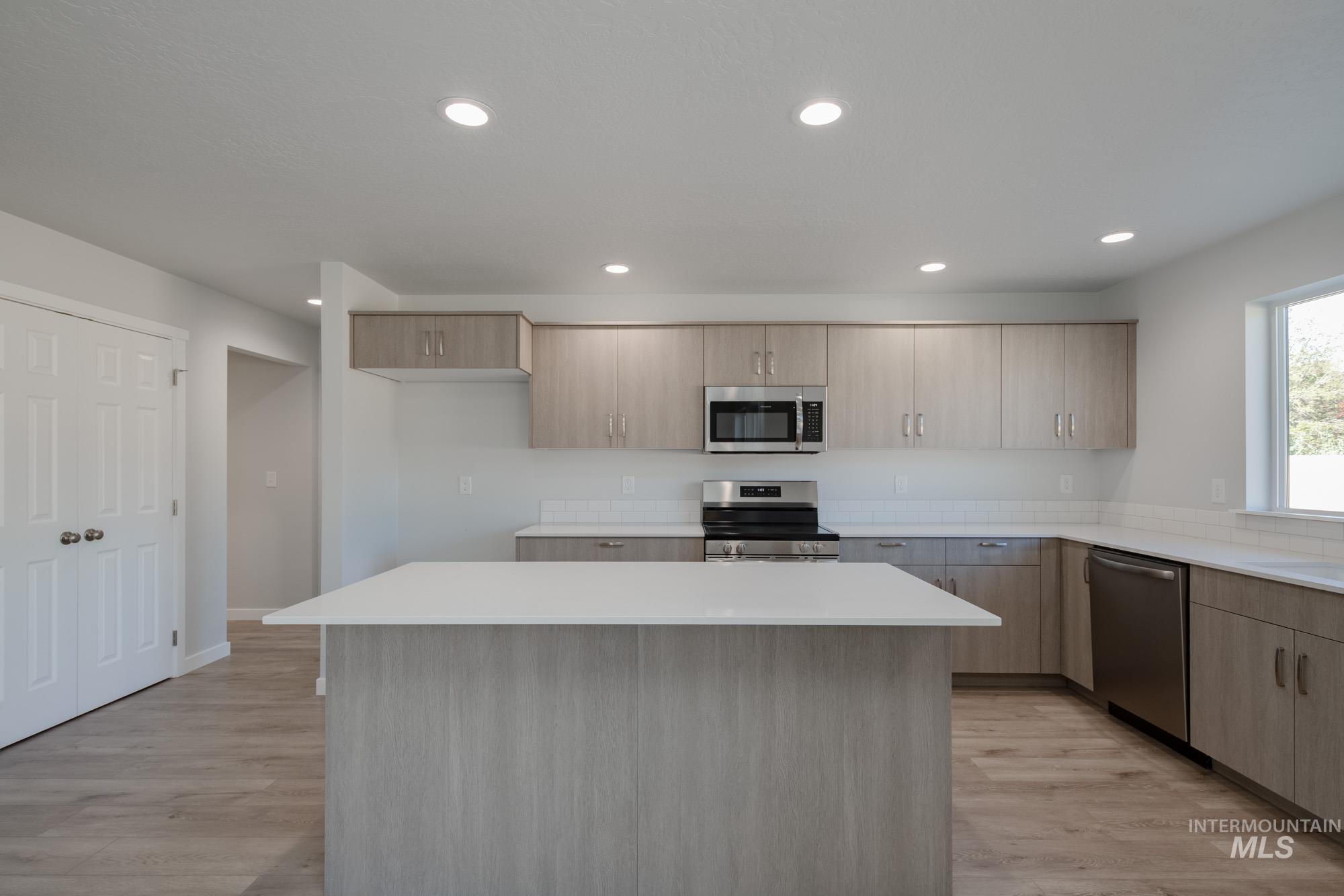 1732 Webb Brk Street Middleton, ID 83644 - Photo 5 of 29 Kitchen with stainless steel appliances, a kitchen island, light brown cabinets, light wood-type flooring, and modern cabinets