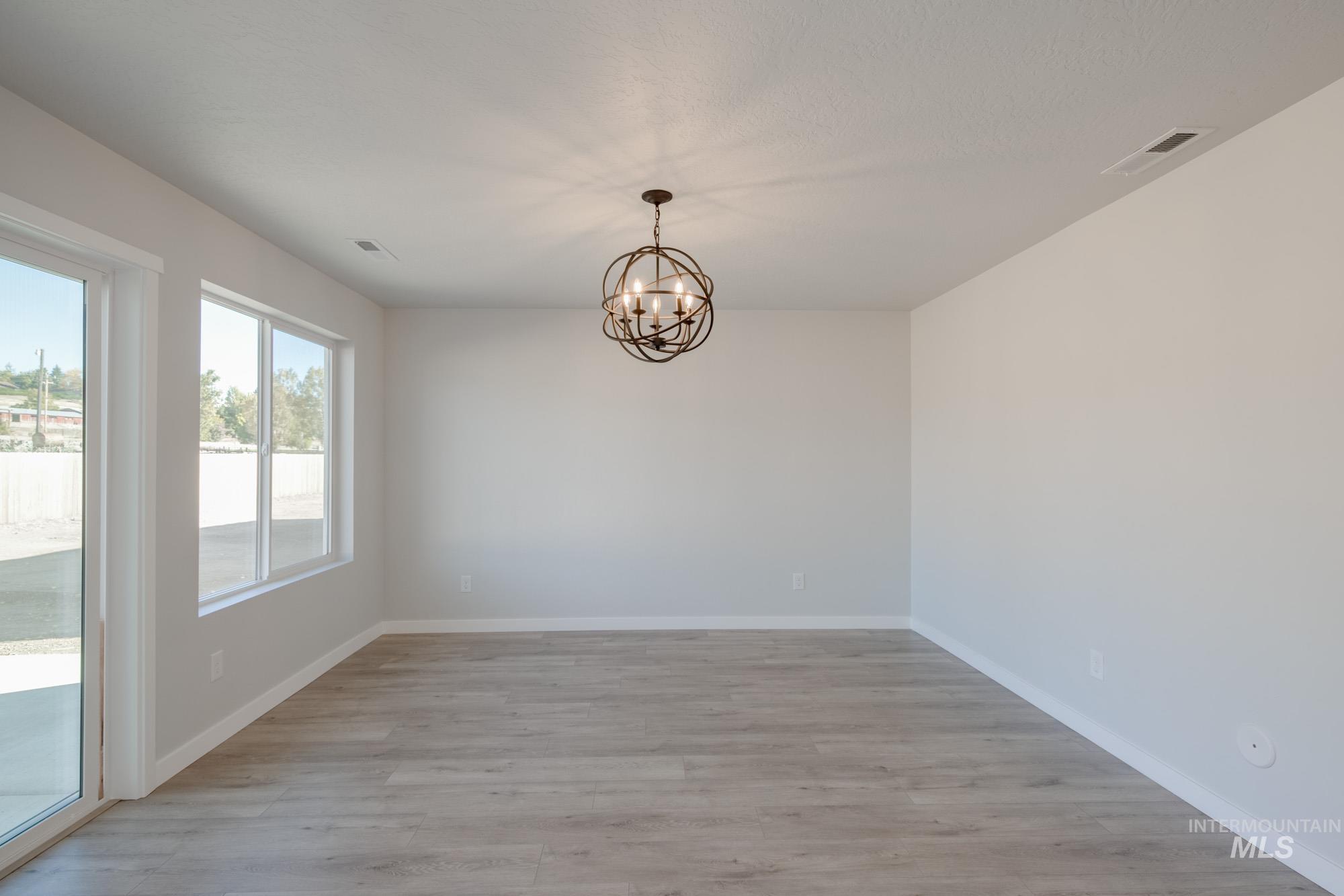 1732 Webb Brk Street Middleton, ID 83644 - Photo 10 of 29 Unfurnished dining area featuring light wood-type flooring and a chandelier