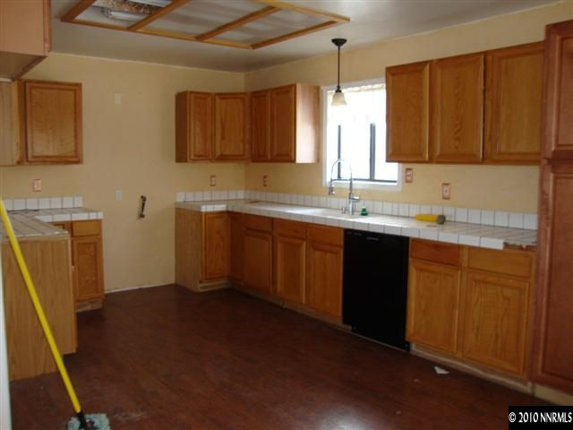 3655 Amy Road Reno, NV 89510 - Photo 4 of 4 a kitchen with a sink a stove a refrigerator and wooden cabinets