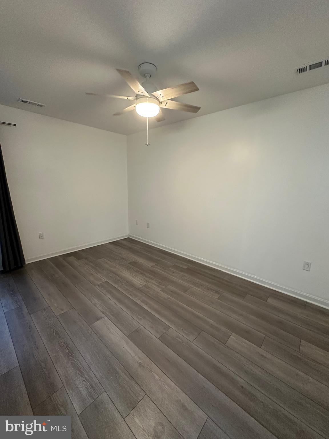 932 12th Street Pasadena, MD 21122 - Photo 12 of 14 an empty room with wooden floor and fan
