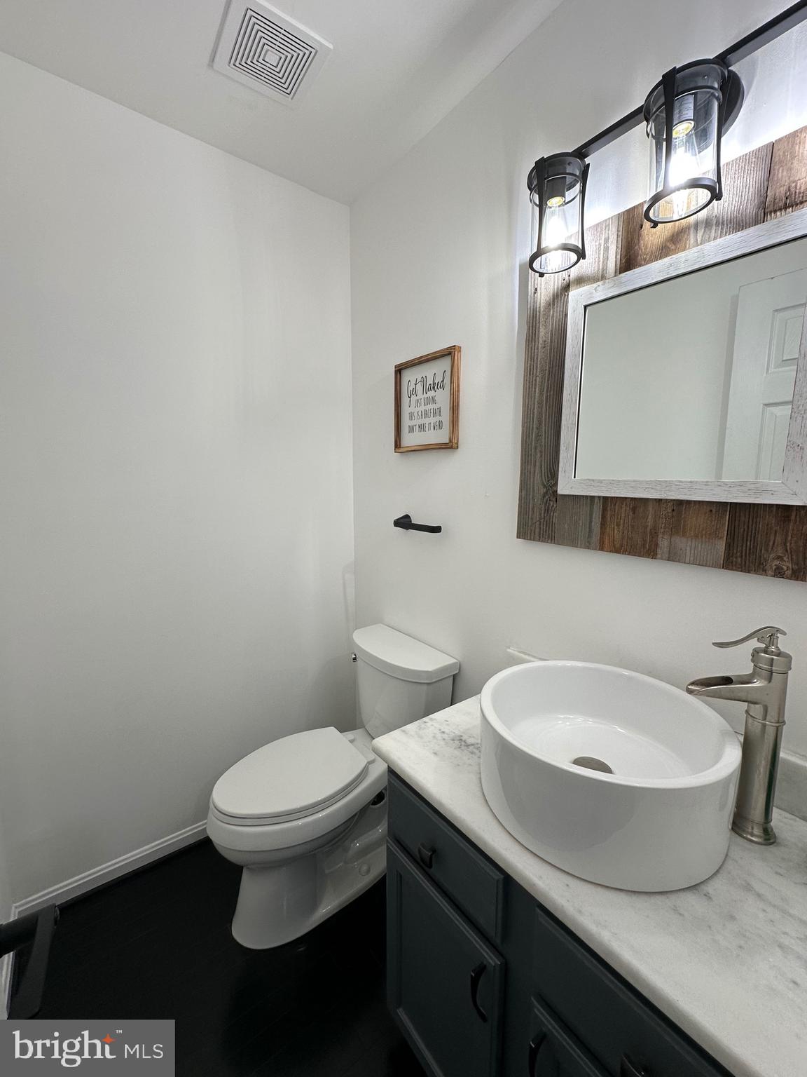 932 12th Street Pasadena, MD 21122 - Photo 14 of 14 a bathroom with a toilet a sink and mirror