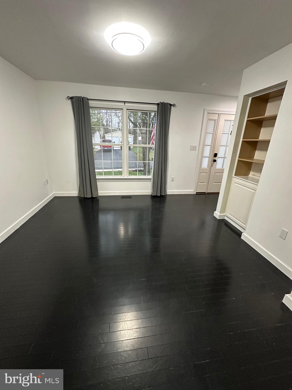 932 12th Street Pasadena, MD 21122 - Photo 2 of 14 a view of an empty room with wooden floor and a window
