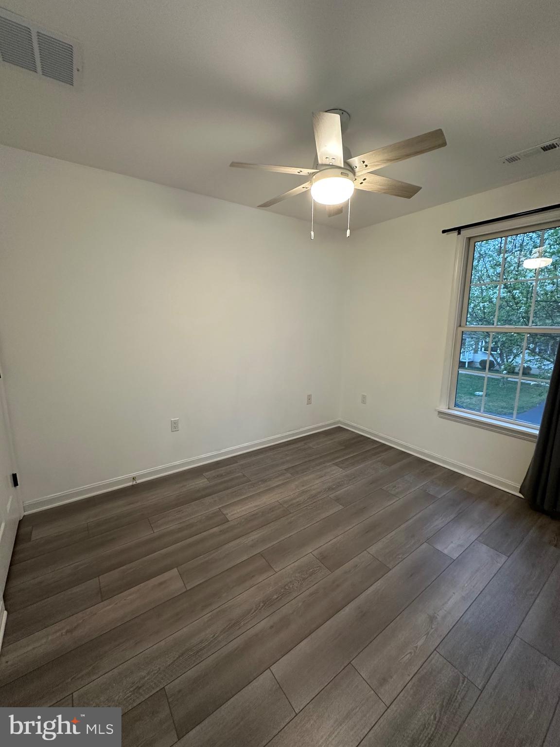 932 12th Street Pasadena, MD 21122 - Photo 8 of 14 an empty room with wooden floor fan and windows