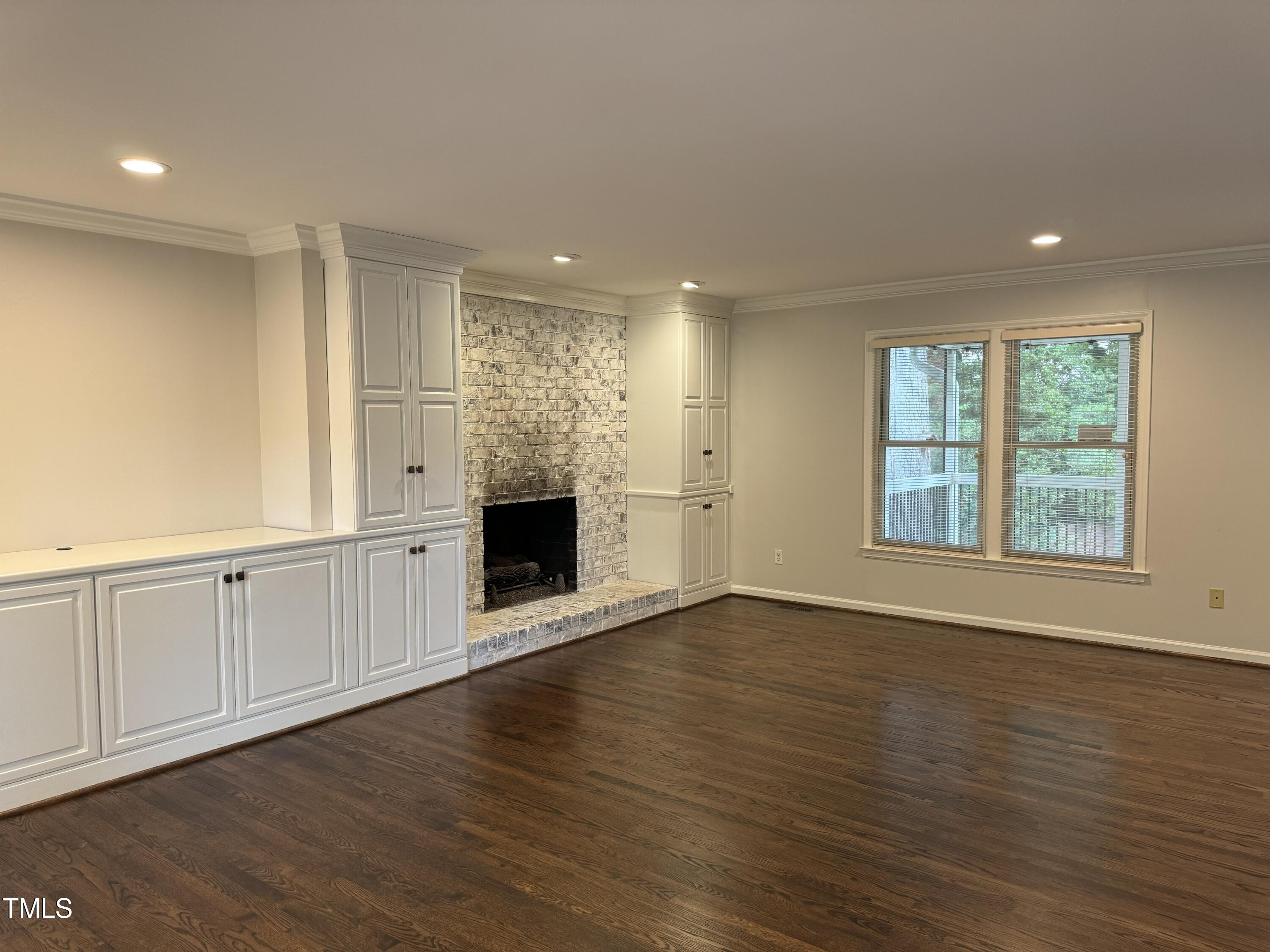 2501 Ferguson Road Raleigh, NC 27612 - Photo 4 of 30 a view of an empty room with wooden floor and a window