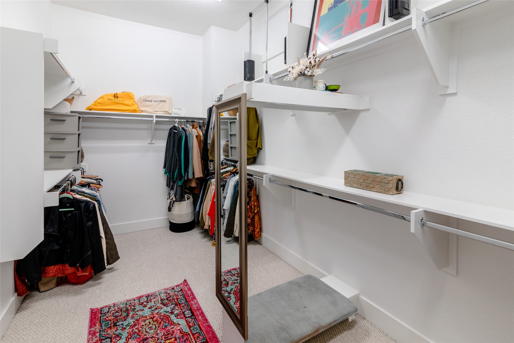 6025 Seville Drive Austin, TX 78724 - Photo 19 of 40 1 of 2 spacious primary walk-in closet featuring built-in shelving, multiple hanging rods