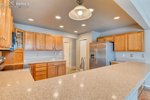 a large kitchen with stainless steel appliances granite countertop a sink refrigerator and cabinets