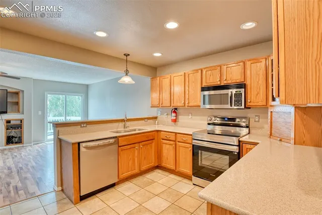 a kitchen with stainless steel appliances granite countertop a stove a sink dishwasher and a refrigerator with wooden floor