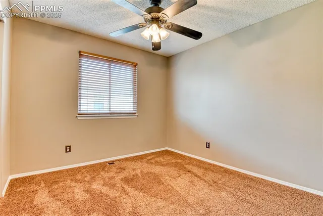 a view of a room with a ceiling fan and a window