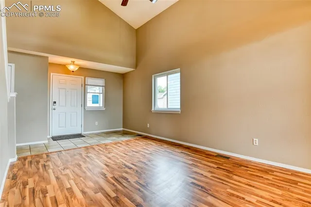 a view of empty room with window and wooden floor