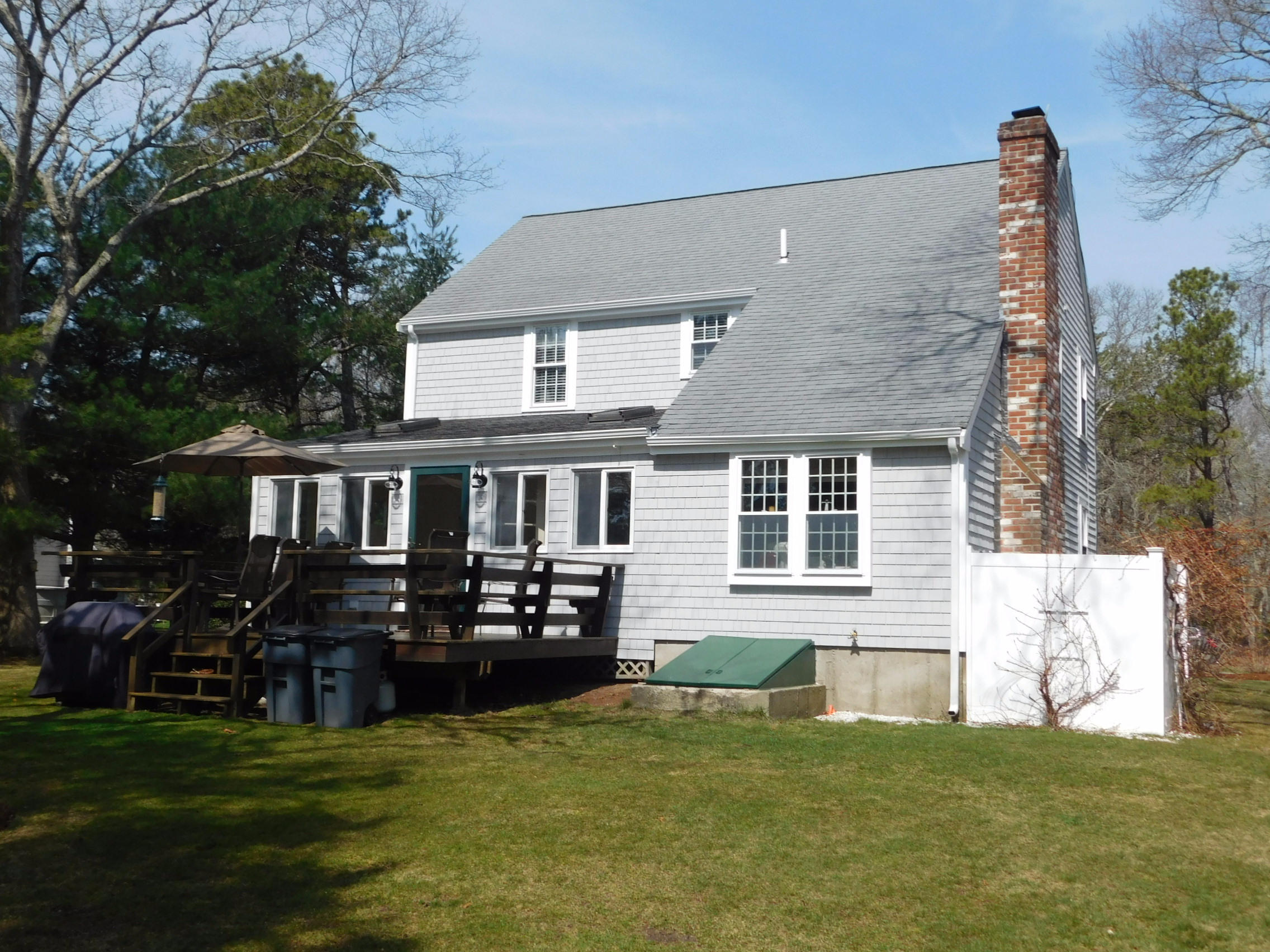 17 Captain Carltons Road Cotuit, MA 02635 - Photo 2 of 26 a front view of a house with a garden