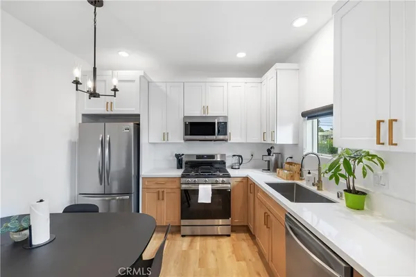 a kitchen with a sink a counter top space stainless steel appliances and a window